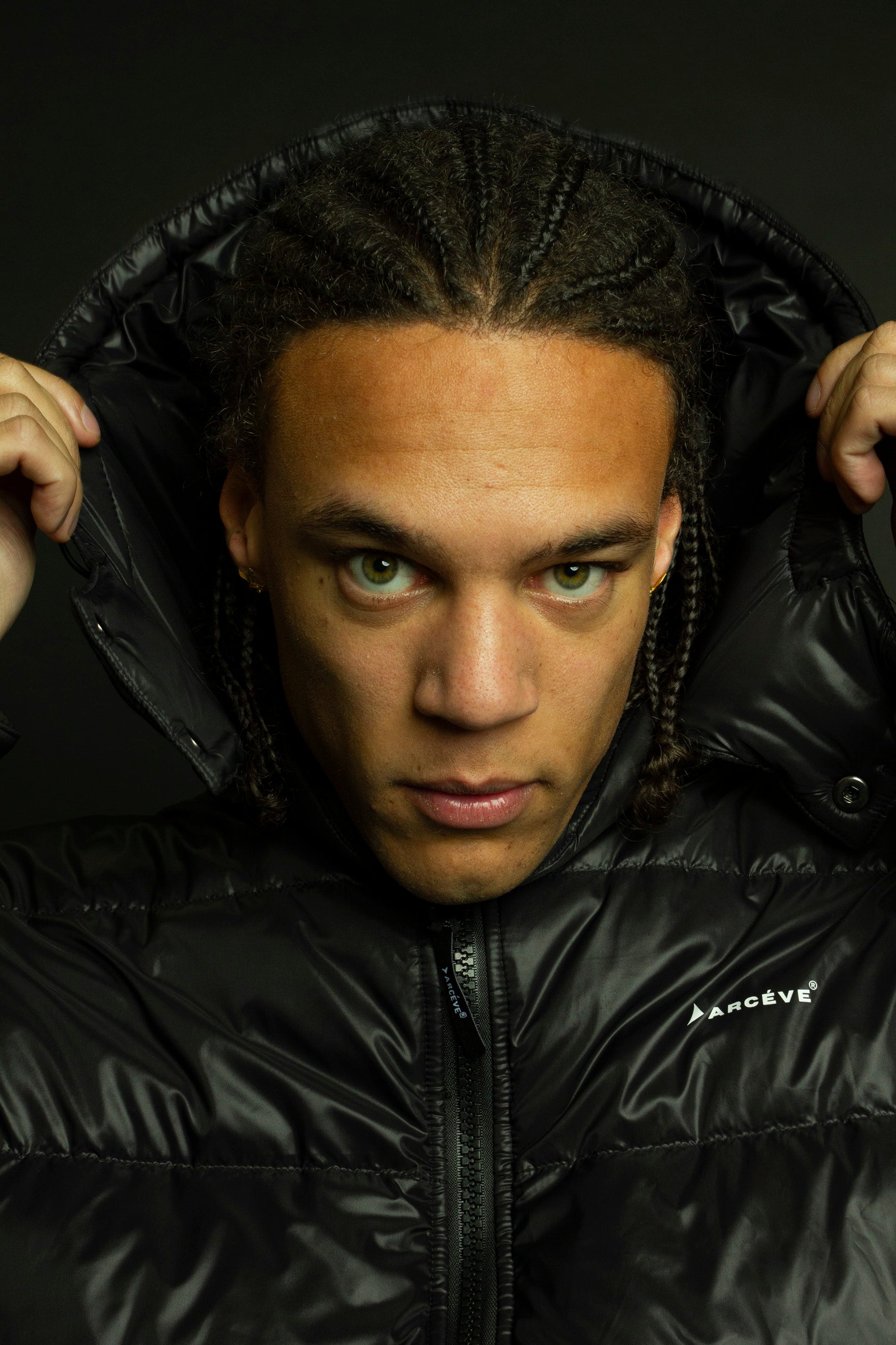 ARCÉVE The Mont Jacket - Close-up of the signature ARCÉVE logo on the chest black hooded down jacket