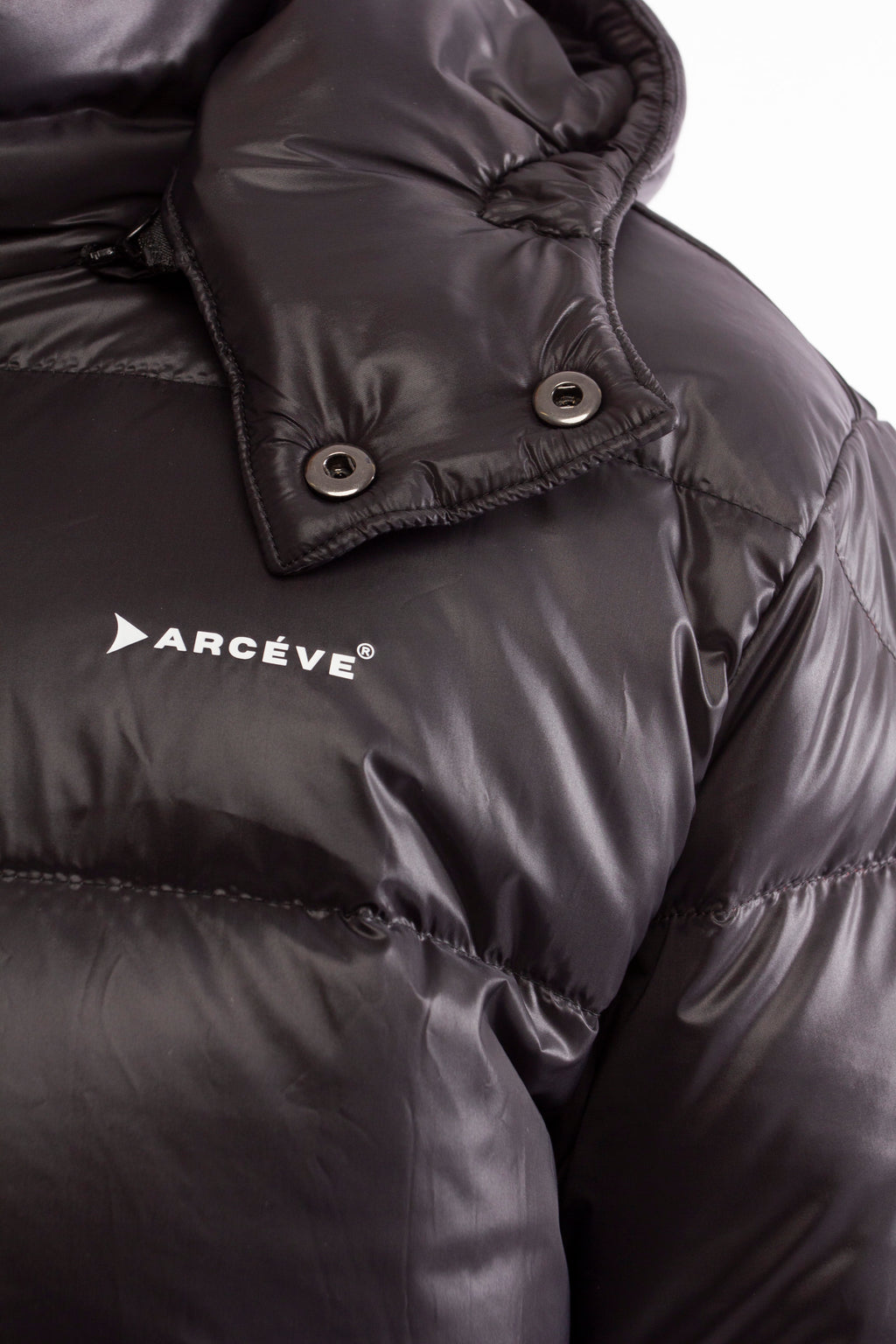 ARCÉVE The Mont Jacket - Close-up of the signature ARCÉVE logo on the chest - Black