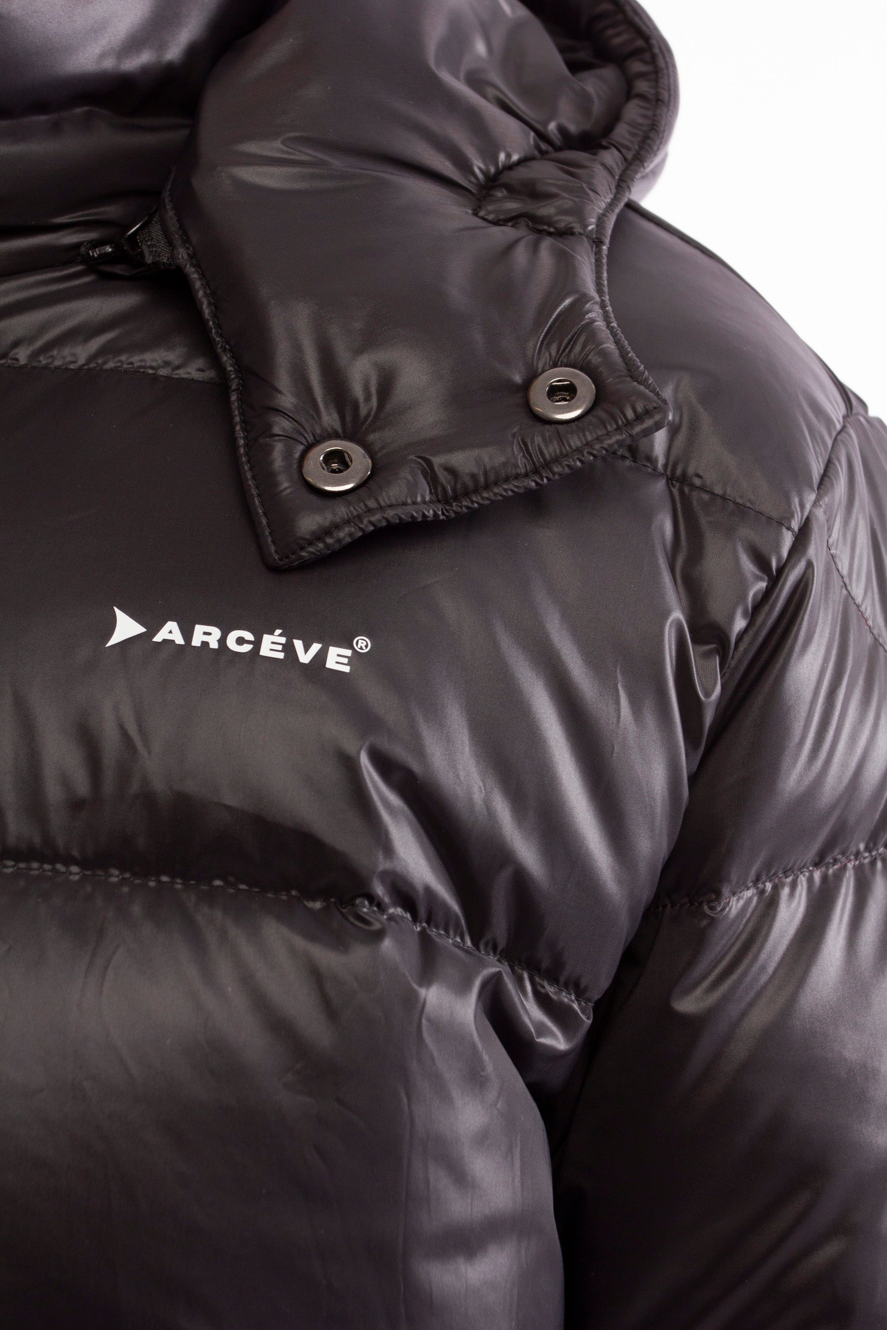 ARCÉVE The Mont Jacket - Close-up of the signature ARCÉVE logo on the chest - Black